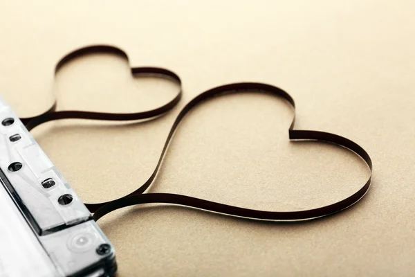Аудиокассета с магнитной лентой в форме сердец на коричневом фоне — стоковое фото