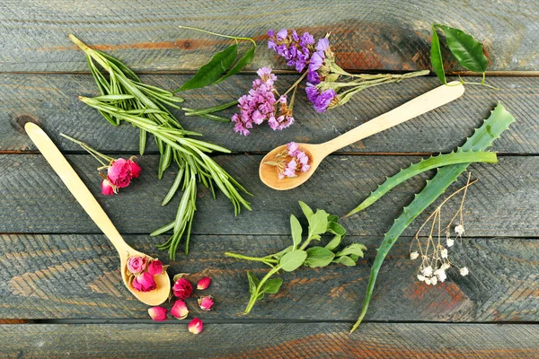 Groene kruiden en bladeren op houten tafel, bovenaanzicht — Stockfoto