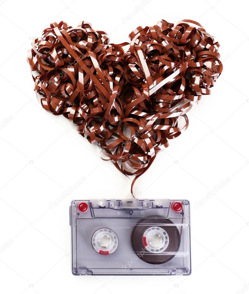 Audio cassette with magnetic tape in shape of heart isolated on white