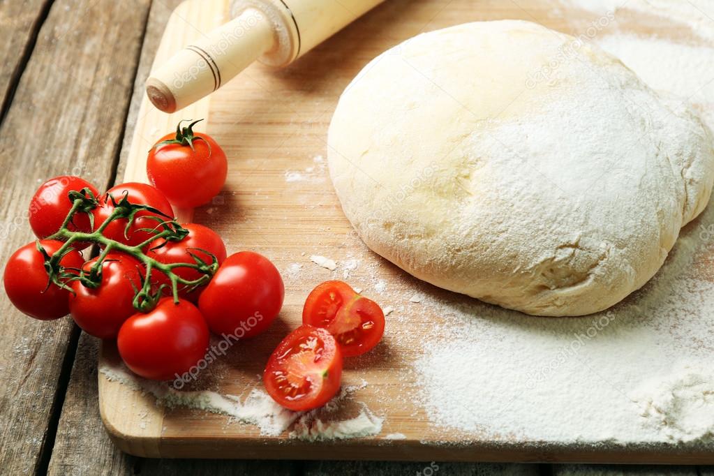 Dough on cutting board with cherry on table close up