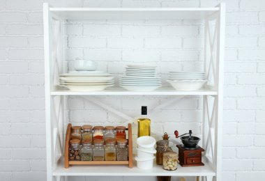 Beyaz tuğla duvar arka plan üzerinde yemekleri ile raf mutfak