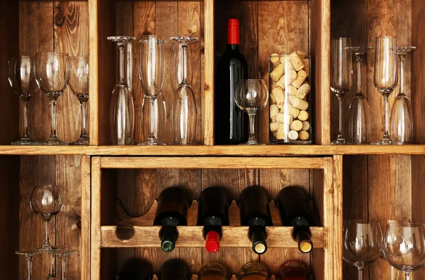Hyllor med vinflaskor med glasögon på trävägg bakgrund — Stockfoto
