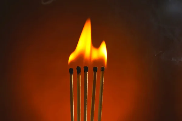 Brinnande matcher med rök på mörk färg bakgrunden — Stockfoto