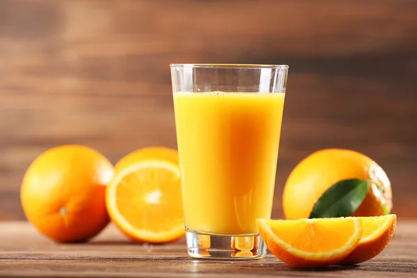 Sumo de laranja na mesa no fundo de madeira — Fotografia de Stock