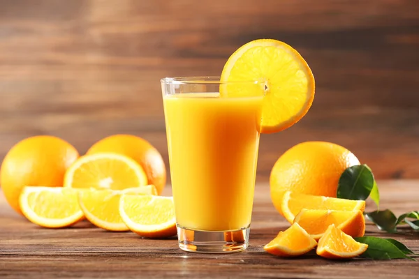 Jugo de naranja sobre mesa sobre fondo de madera — Foto de Stock