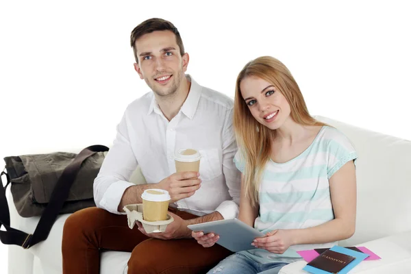 Retrato de joven pareja feliz con equipaje, sentado en el sofá. Aislado sobre blanco — Foto de Stock