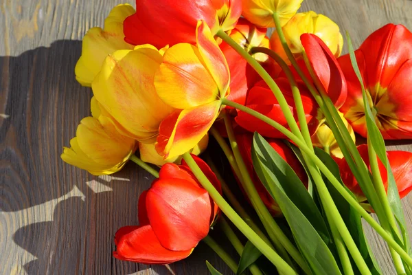 Hermosos tulipanes coloridos en la mesa de madera, primer plano —  Fotos de Stock