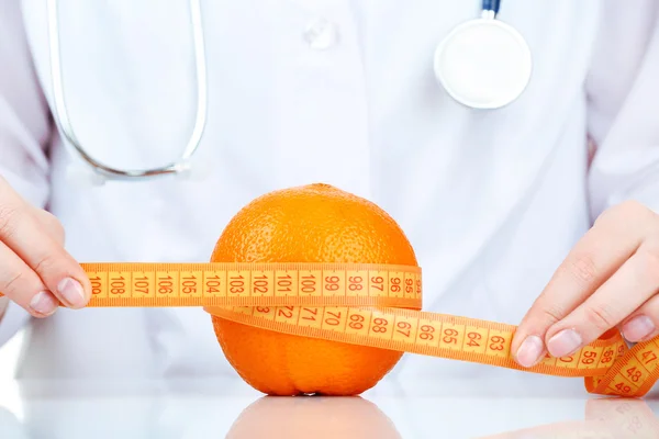 Médico nutricionista com frutas e fita métrica, close-up — Fotografia de Stock