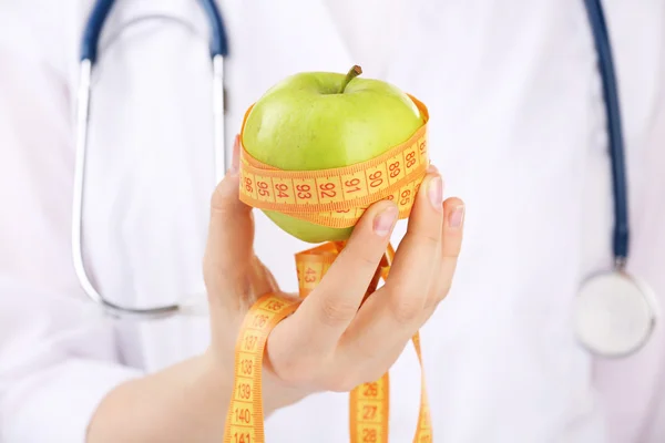 Nutricionista médico con manzana y cinta métrica, primer plano — Foto de Stock