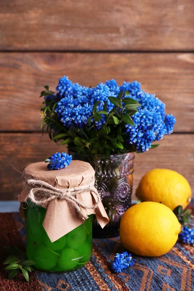 Limon ve kiraz likörü vişne cam ahşap zemin üzerine mavi çan çiçeklerle — Stok fotoğraf