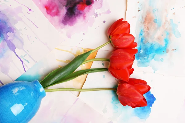 Red tulips in vase on watercolor sketches background top view — Stock Photo, Image