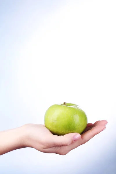 Kvinnlig hand med apple på färgstarka bakgrund — Stockfoto