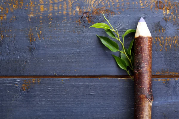 Lápiz de madera con hoja sobre fondo de madera — Foto de Stock