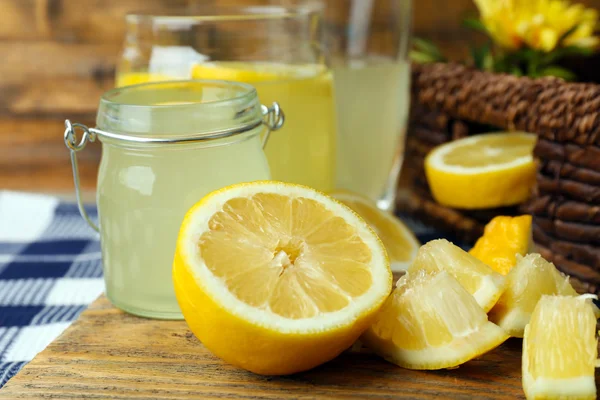 Limon suyu ve ahşap kesme tahtası, closeup üzerine dilimlenmiş limon ile natürmort — Stok fotoğraf