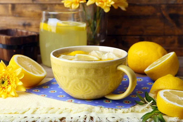 Bodegón con jugo de limón y limones en rodajas sobre mesa de madera con servilleta, primer plano —  Fotos de Stock