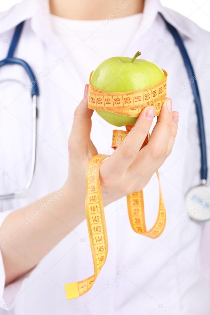 Nutritionist doctor with apple and measuring tape, closeup