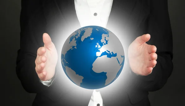 Female hands showing globe on dark background — Stock Photo, Image