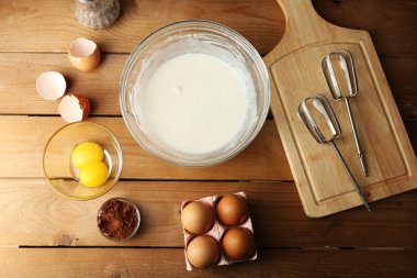 Hazırlık ahşap masa, üstten görünüm üzerinde cam kasede yumurta ile krem