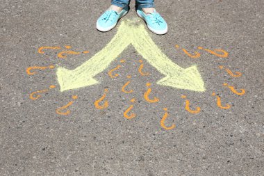 Female feet making choice on asphalt with drawing arrows, outdoors clipart