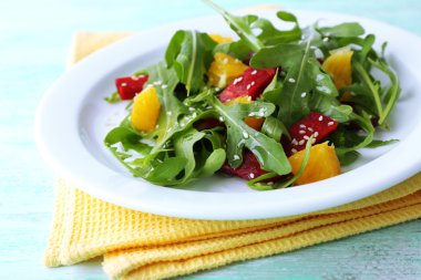 Roka ile lezzetli salata tabağına ahşap masa, closeup bırakır.