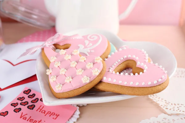 Печенье в форме сердца на день Святого Валентина на тарелке, на цветном деревянном фоне — стоковое фото