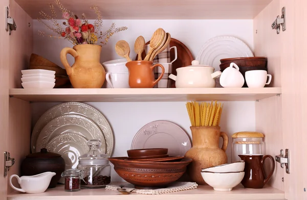 Kitchen utensils and tableware on wooden shelves — Stock Photo, Image