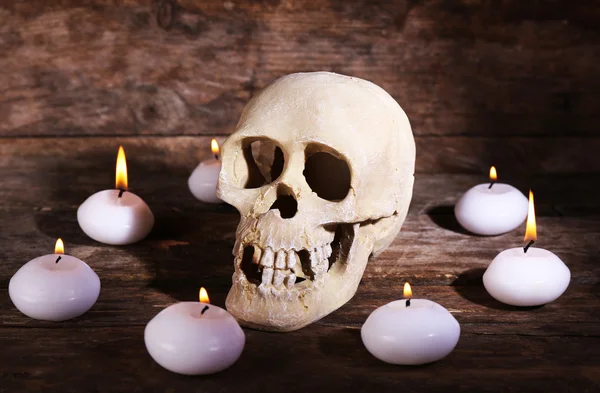 Still life with human skull and candles on wooden background — Stock Photo, Image