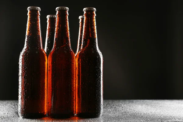 Botellas de vidrio de cerveza sobre fondo oscuro —  Fotos de Stock