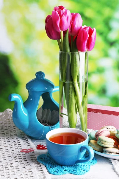 Composition of spring flowers, tea and cookies on table on natural background — Stock Photo, Image