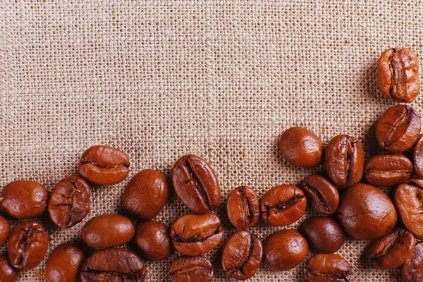 Frame van koffie bonen op zak achtergrondkleur — Stockfoto