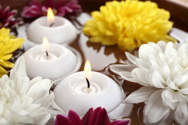 Cuenco de agua de spa con flores y velas, primer plano —  Fotos de Stock