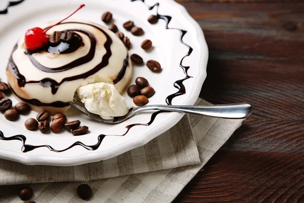 Tasty panna cotta dessert on plate, on wooden table — Stock Photo, Image