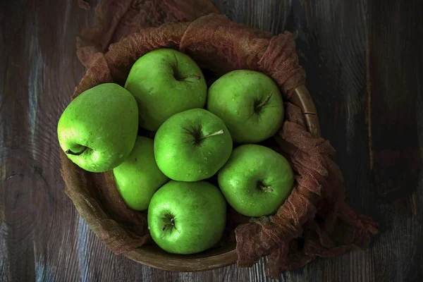 Pommes vertes dans un bol avec tissu sur une table en bois, vue sur le dessus — Photo
