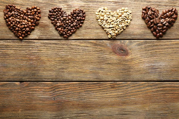 Granos de café sobre fondo de madera — Foto de Stock