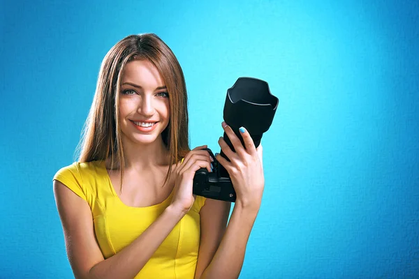 Joven fotógrafa tomando fotos sobre fondo azul —  Fotos de Stock