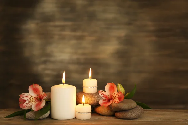 Hermosa composición con velas y piedras de spa sobre fondo de madera — Foto de Stock