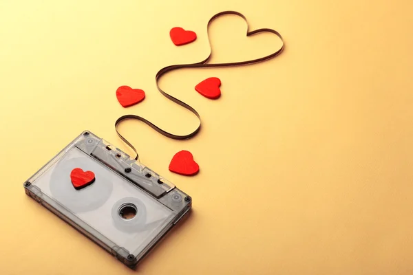 Cassette de audio con cinta magnética en forma de corazón sobre fondo amarillo — Foto de Stock