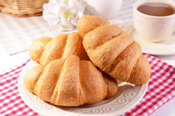 Läckra croissanter på tallriken på bordet närbild — Stockfoto