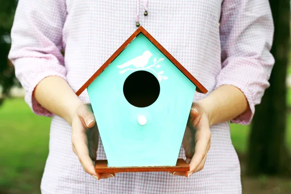 Decorative nesting box in female hands on bright background — Stock Photo, Image