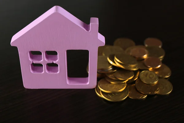 Model van huis met munten op houten tafel, close-up — Stockfoto