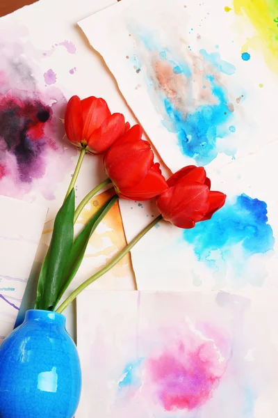 Red tulips in vase on watercolor sketches background top view — Stock Photo, Image