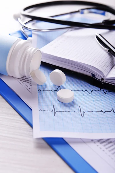 Cardiograma con pastillas en la mesa, primer plano — Foto de Stock