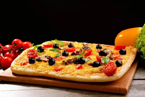 Deliciosa pizza caseira na mesa no fundo preto — Fotografia de Stock