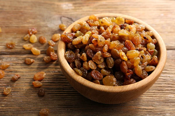 Raisins in bowl on wooden table, closeup — Stock Photo, Image