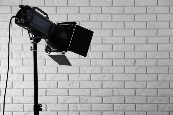 Photo studio with lighting equipment on brick wall background — Stock Photo, Image