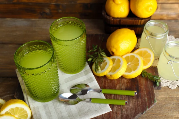 Naturaleza muerta con jugo de limón y limones en rodajas en la mesa de madera, primer plano —  Fotos de Stock