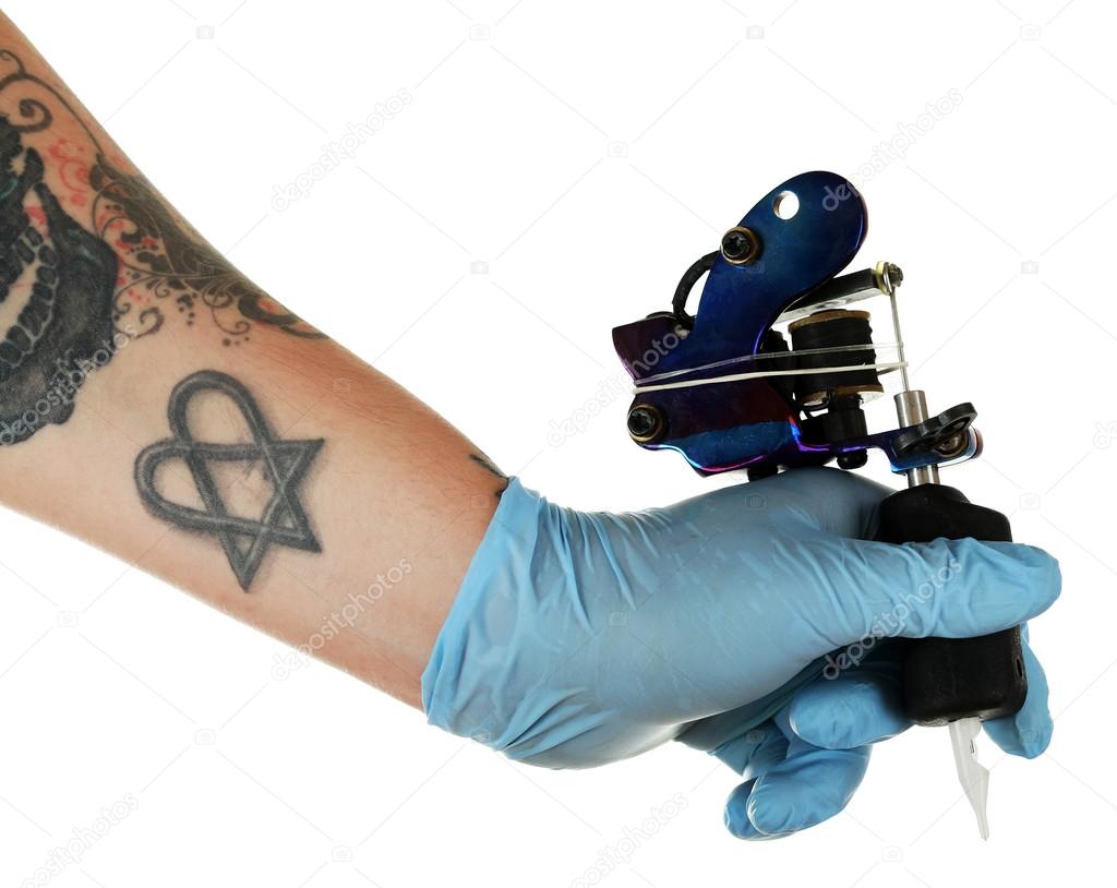 Hand of tattoo artist with tattoo machine isolated on white