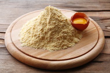 Ahşap masa yumurta ile kesme tahtası üzerinde un yığını