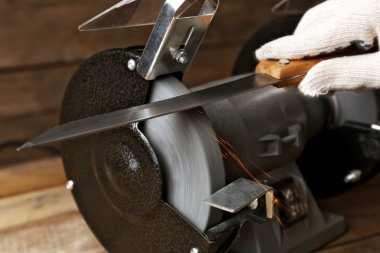 Bıçak Bileyici ve ahşap masa, closeup üzerinde bıçak el