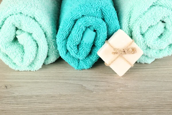 Hermosas toallas con jabón sobre fondo de madera — Foto de Stock